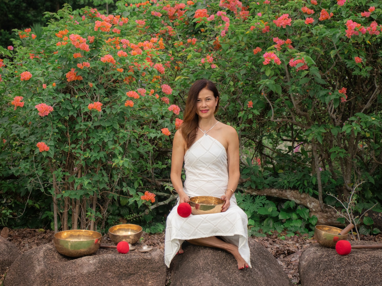 Claire, seated in a garden holding a singing bowl